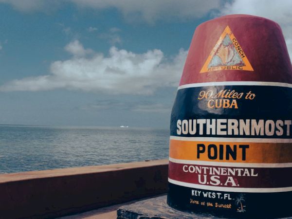 A colorful buoy marks the southernmost point in the continental U.S.A. in Key West, FL, noting "90 Miles to Cuba."